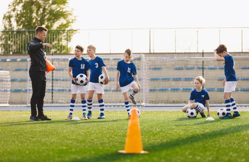 En fotballtrening der treneren veileder spillerne sine.